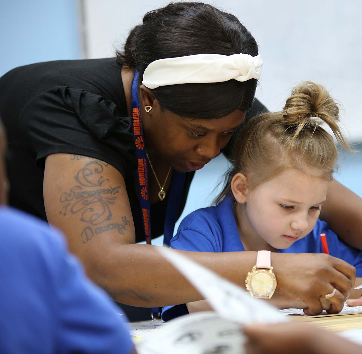 Horizon Science Academy Dayton Elementary Teacher and student interacting at a classroom desk
