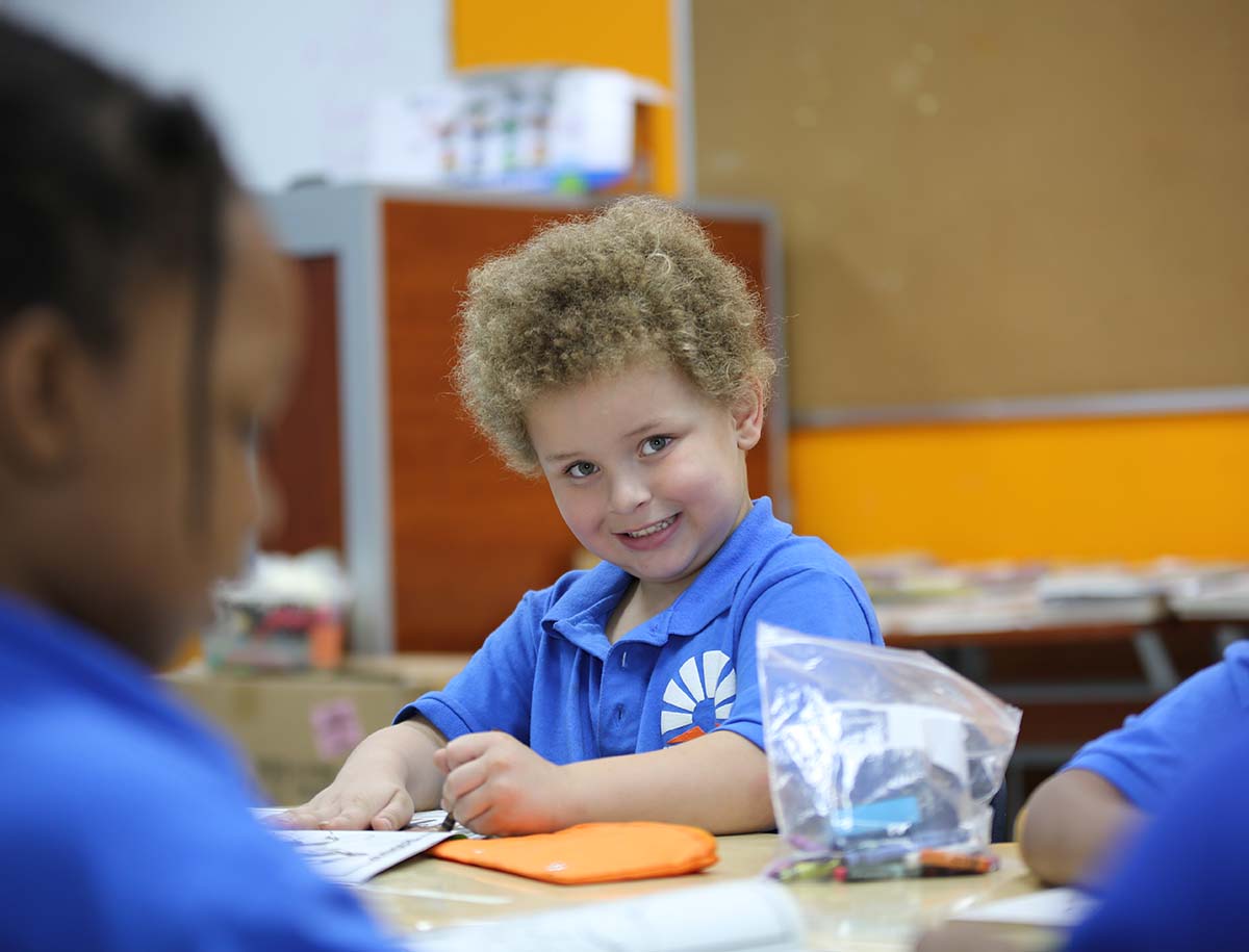 Student working on a notebook in a classroom.